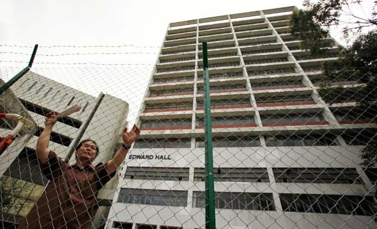 Un guarda de seguretat vigila una escola abandonada que serà demolida per construir un complex residencial de luxe a Hong Kong.