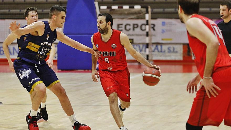 Lucas, del Porriño PBB, bota el balón ante la presión de un rival. | // ALBA VILLAR