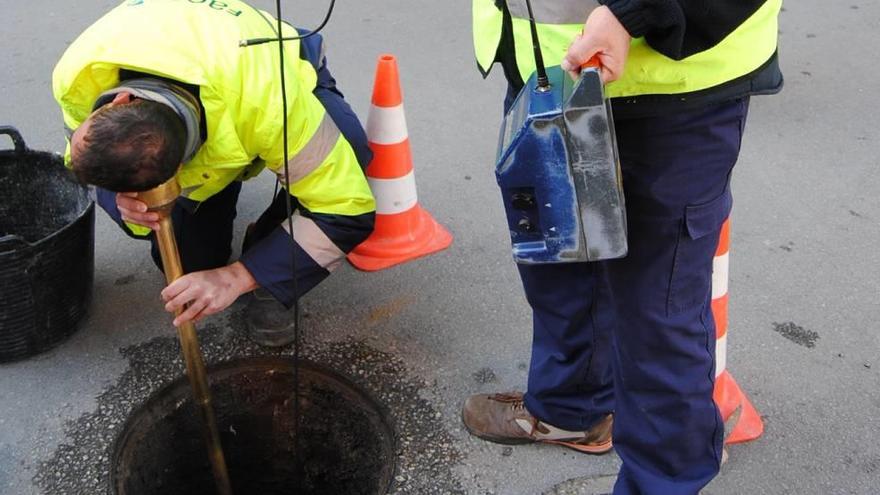 Unos operarios inspeccionando un tramo de fugas.