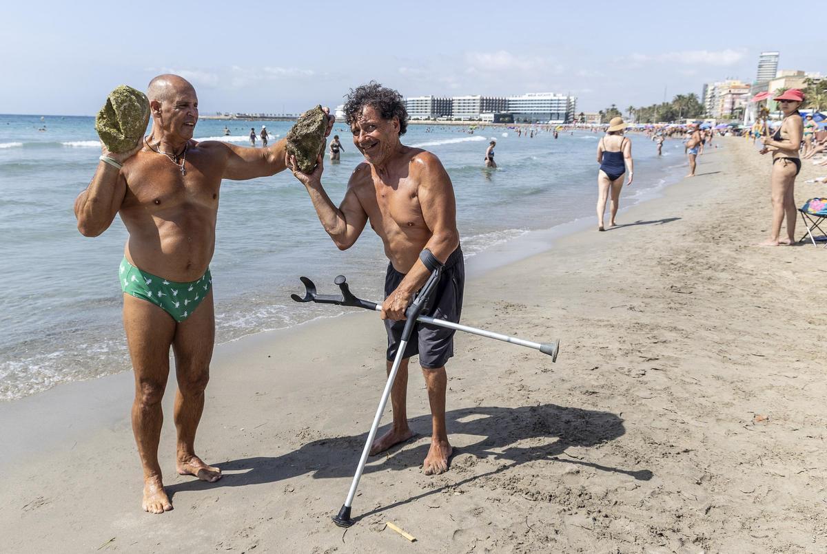 Bañistas enseñan piedras encontradas en El Postiguet el pasado verano.