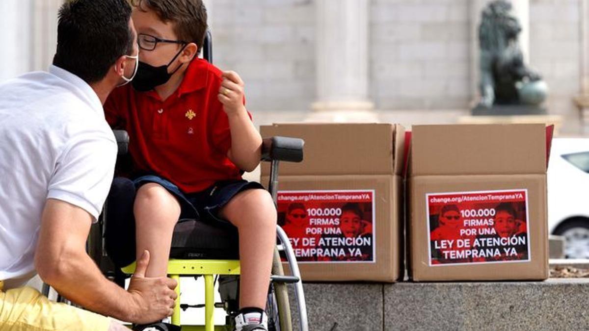 Entrega en el Congreso de los Diputados de 100.000 firmas por una Ley de Atención Temprana, en la imagen Iker besa a su padre.