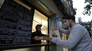 Un cliente compra comida para llevar en un establecimiento de Barcelona.
