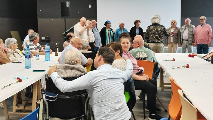 La Coral de Salas interpreta una pieza mientras el alcalde conversa con los mayores