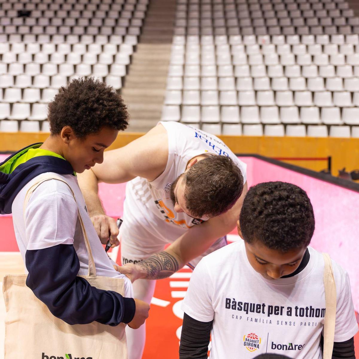 Geben firma la samarreta a un nen.