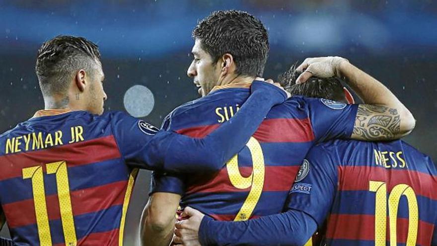 Luis Suárez, al mig, s&#039;abraça amb Neymar i Leo Messi