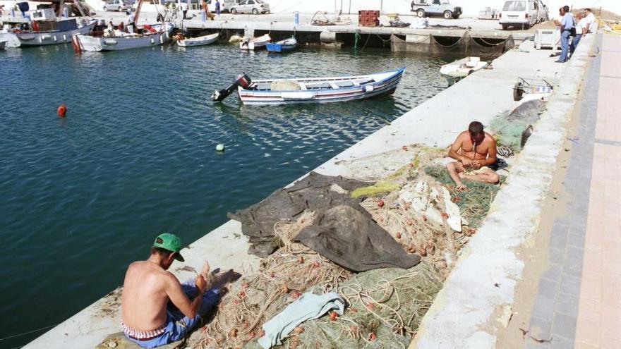 Pescadores arreglan sus redes en el puerto de La Bajadilla.