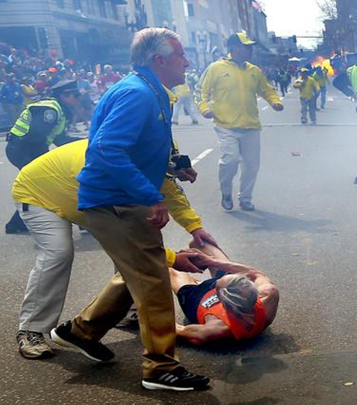 Policia i espectadors ajuden un participant ferit durant l’explosió.