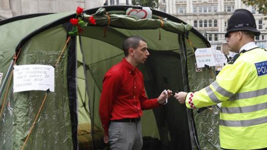 Un policía atiende las explicaciones de un acampado en Londres.