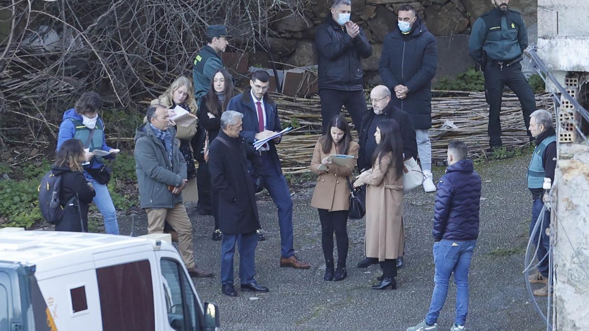 RECONSTRUCCION DEL HOMICIDIO DE CARLOS ALBERTO V.O., CIUDADANO PORTUGUES CUYO CUERPO FUE ENCONTRADO EN EL POZO DE UNA NAVE ABANDONADA EN O PORRIÑO. EN IMAGEN, LA COMISION JUDICIAL Y LOS TRES INVESTIGADOS, ROBERTO Y MARCOS DAVID V. Y SERGIO L.M. ( DOS CON MASCARILLA Y EL VARON DE GABARDINA NEGRA ), EN LA NAVE COARRENDADA A LA VICTIMA EN LA CALLE SEVERINO COBAS, EN VIGO.