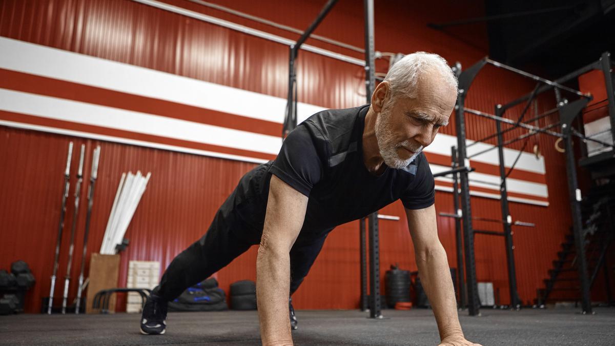 Un deportista senior hace flexiones