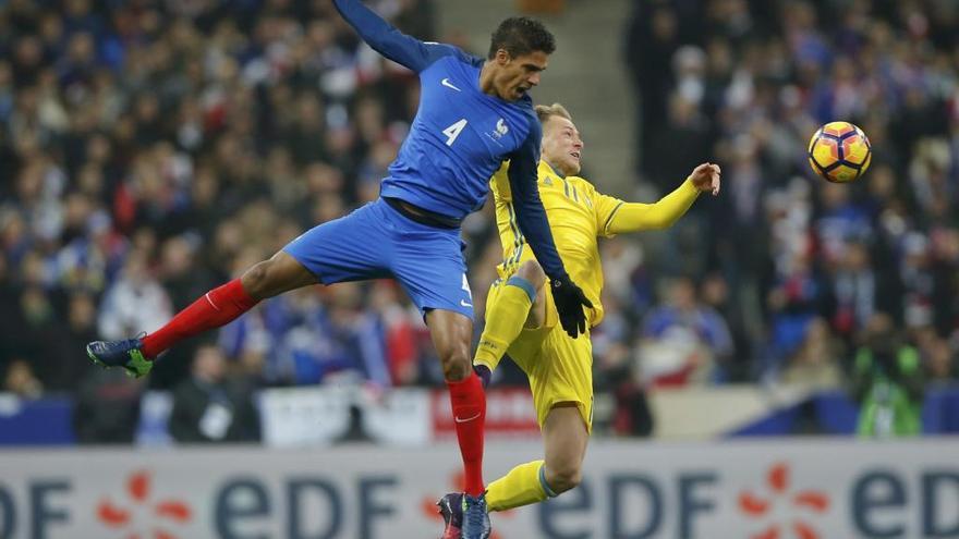 Varane y Guidetti saltan por un balón.