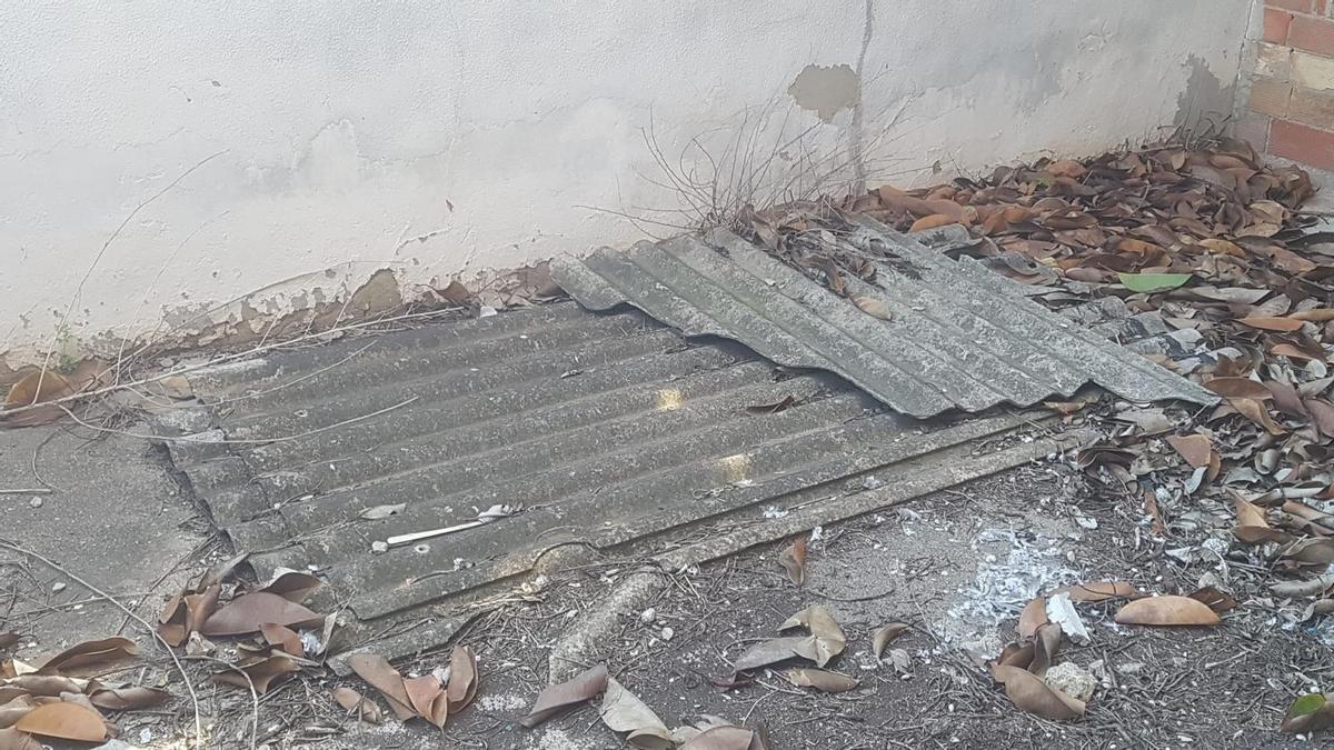Placas de fibrocemento desprendidas de un techado y rotas en el suelo del IES de Benifaió.