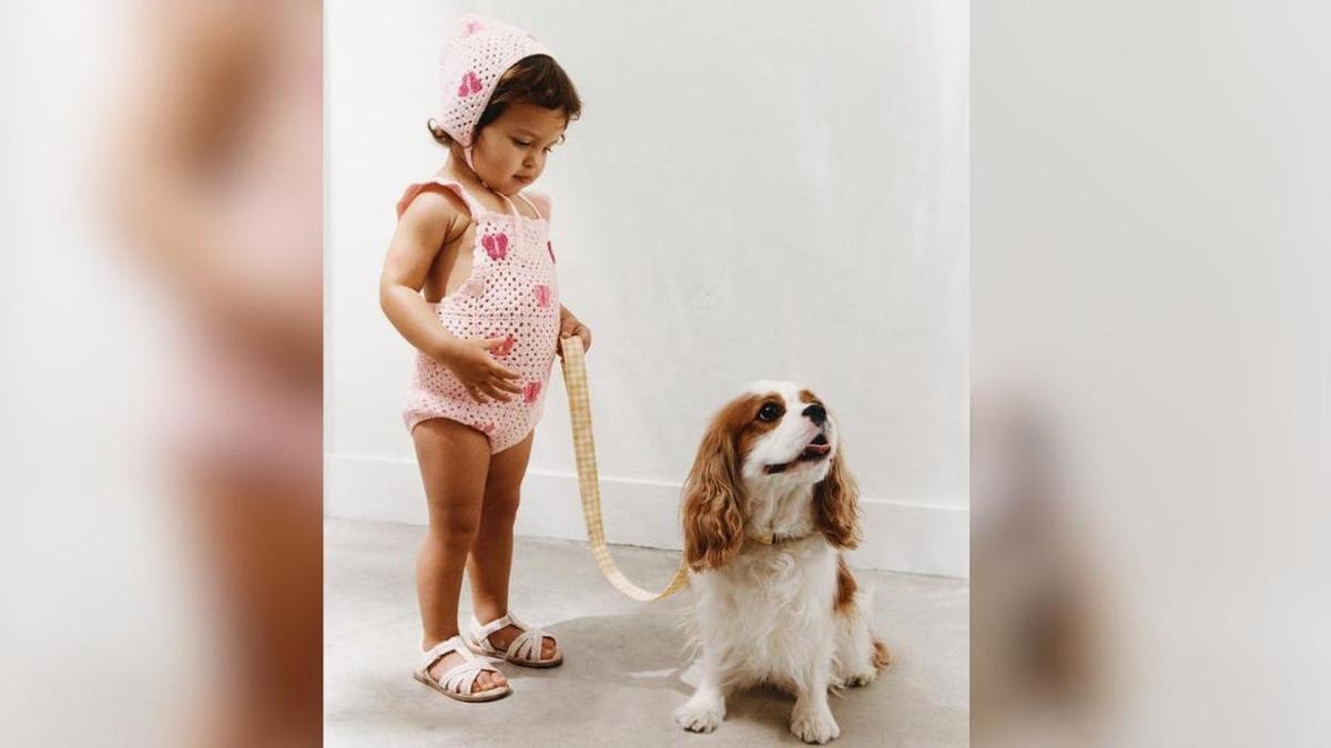 Minnie aparece sentada junto a la niña, que sostiene su correa.