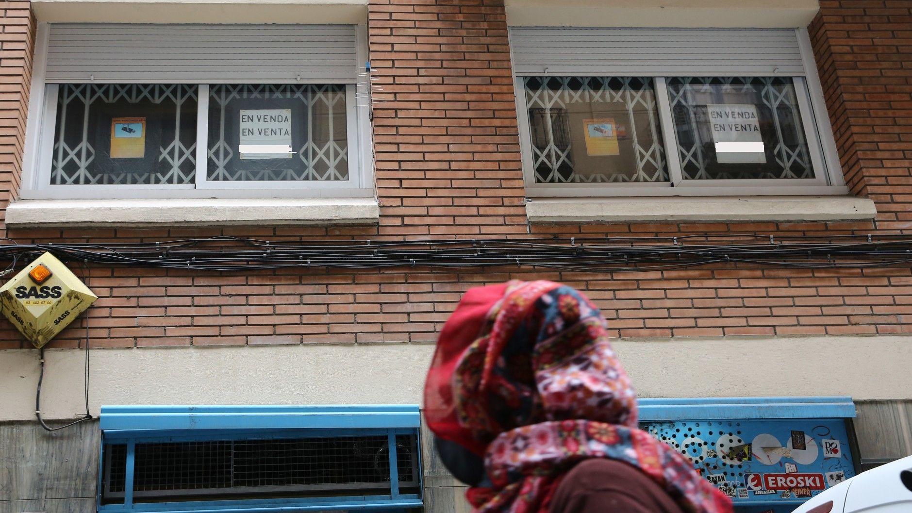 Una mujer mira los carteles de un piso en venta en Barcelona.