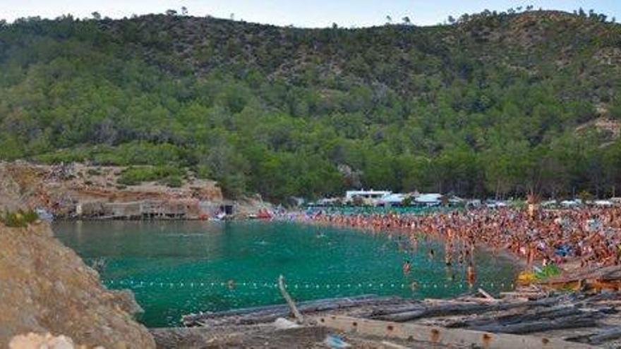 Vista de la zona protegida de Benirràs, con la playa repleta de gente.