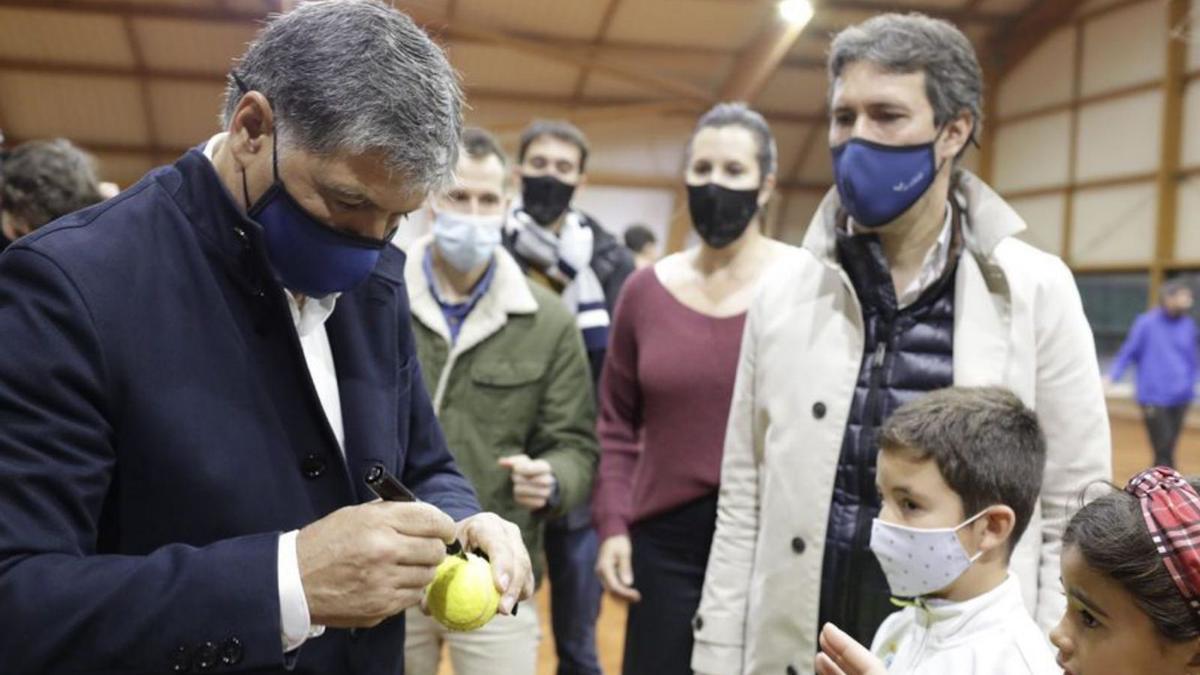 Toni Nadal firma unas pelotas de tenis, ayer, a unos niños