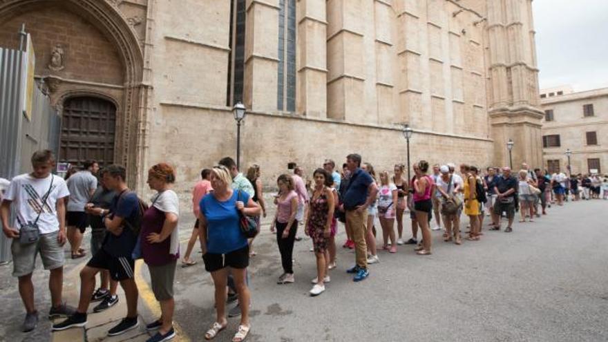 Touristen stehen vor der Kathedrale Schlange.