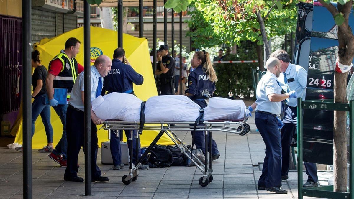 Miembros del servicio funerario trasladan el cadáver de la mujer asesinada en Madrid.