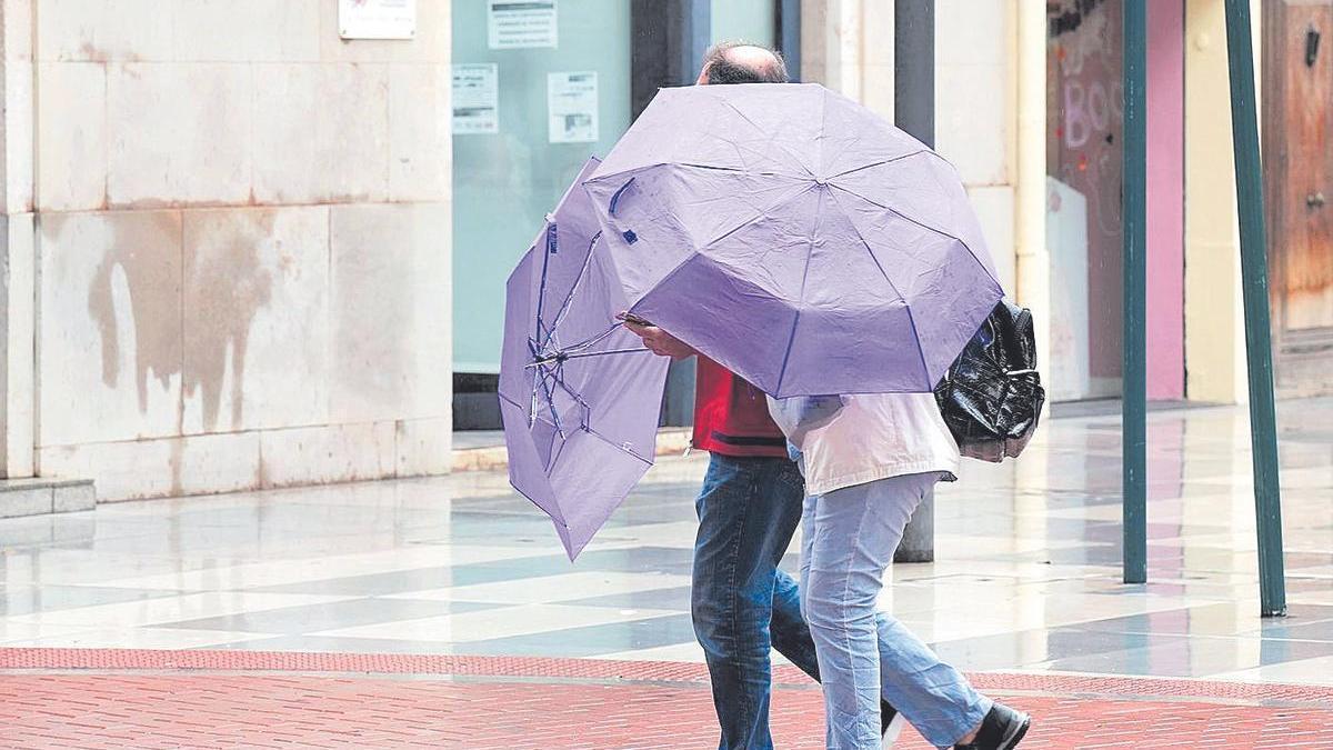 Dos personas con sus paraguas en el centro de Castelló.