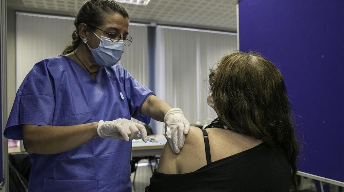 Una mujer recibe la vacuna de AstraZeneca en el centro de vacunación instalado en la facultad de Geografía e Historia de la UB.