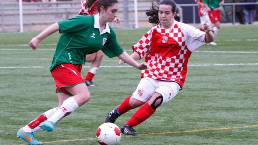 Una jugadora de País Vasco se dispone a superar a una defensora de Castilla y León.