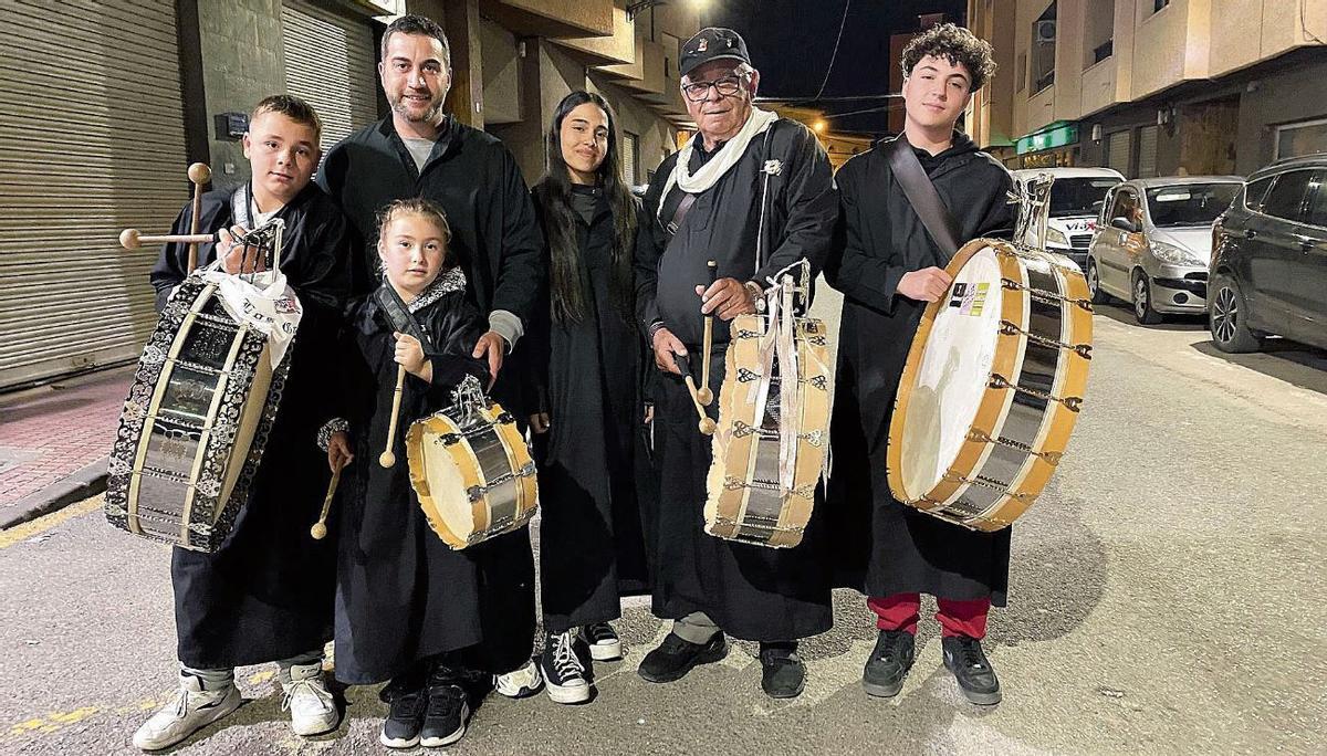 Una familia carga con sus instrumentos en la Noche de los Tambores de Mula.