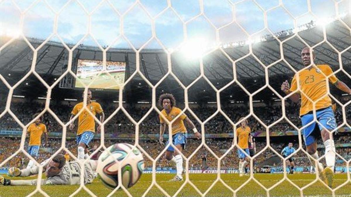 Julio César y la defensa de Brasil asiste impotente a un gol de Alemania.