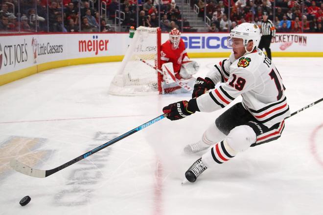 Jonathan Toews # 19 de los Chicago Blackhawks intenta controlar el disco frente a Jonathan Bernier # 45 de los Detroit Red Wings durante el tercer período en Little Caesars Arena, en Detroit, Michigan.