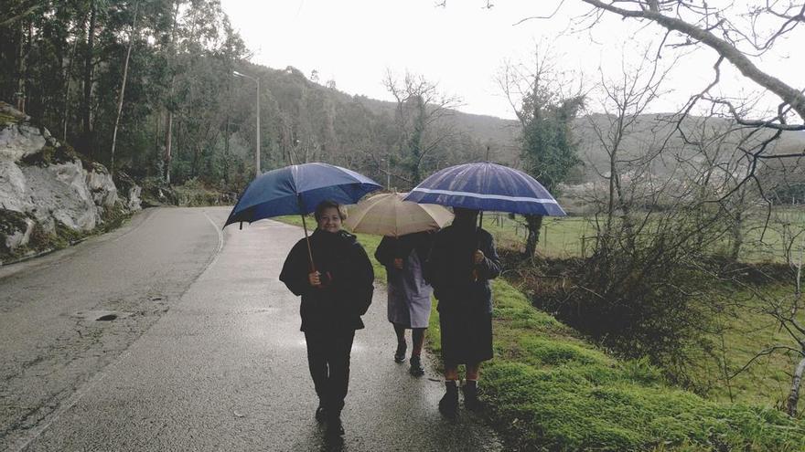 Tres vecinas de Baredo realizaban ayer su ruta diaria, obligadas a caminar por la calzada. // FdV