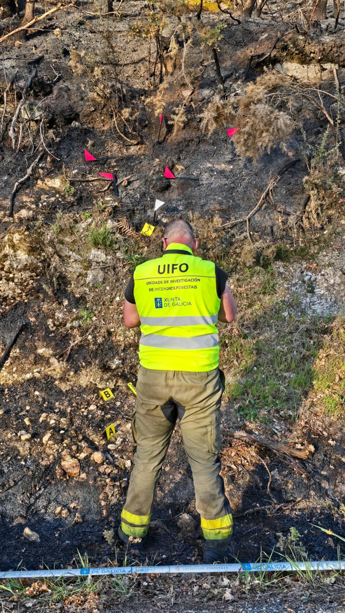 Un investigador de la UIFO inspecciona una zona quemada.