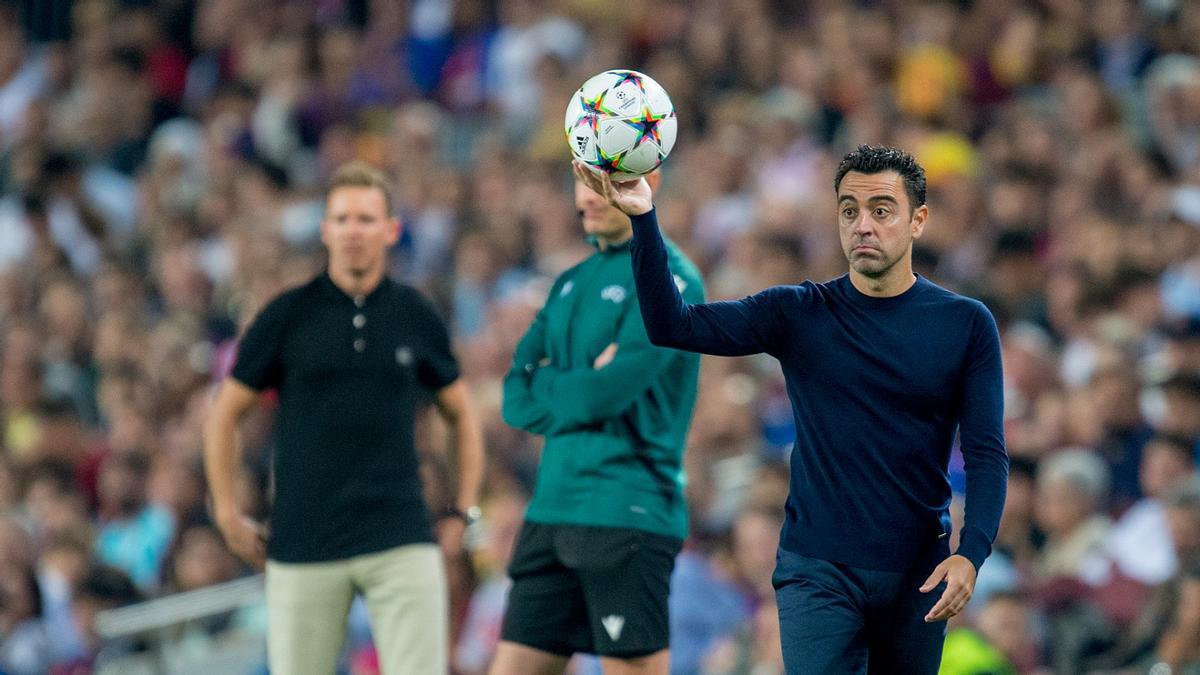 Xavi, con el balón, espera la llegada de un jugador ante Nagelsmann, técnico del Bayern, en el Camp Nou.