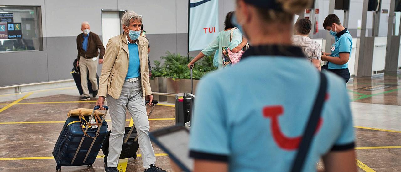 Una trabajadora de TUI recibe a los turistas en el Aeropuerto de Tenerife Sur.  | | CARSTEN W. LAURITSEN