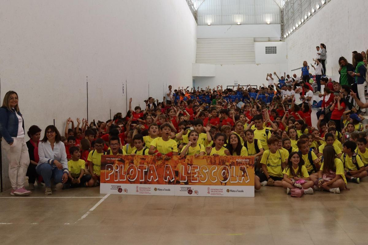 L'alumnat dels 23 centres reunits a la Trobada de Primària de Pilota a l'Escola de Canals es van fer la foto de grup al trinquet municipal.