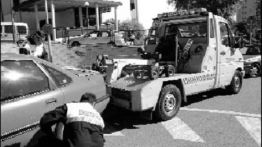 Una grúa retira un vehículo mal estacionado en una calle de Benidorm