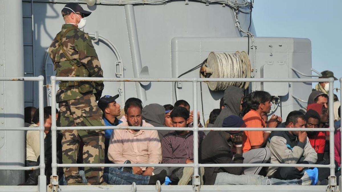 Migrantes en la cubierta de un barco militar francés, a su llegada al puerto de Crotone, en el sur de Italia, tras una operación de rescate de la misión conjunta Tritón, el 3 de mayo del 2015.