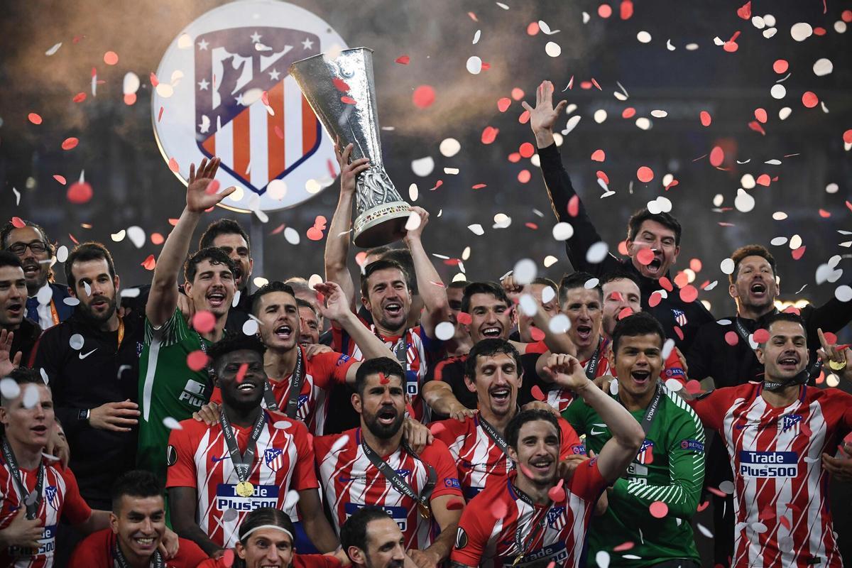 Atletico's players celebrate with the trophy after the UEFA Europa League final football match between Olympique de Marseille and Club Atletico de Madrid at the Parc OL stadium in Decines-Charpieu, near Lyon on May 16, 2018. / AFP PHOTO / FRANCK FIFE. HORIZONTAL