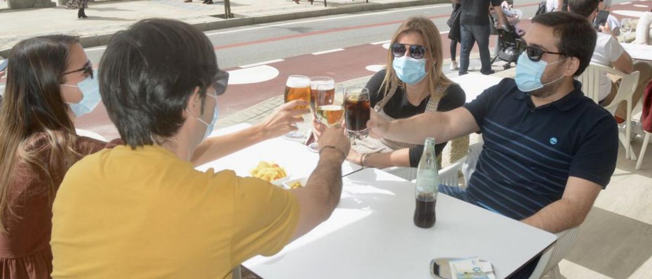 Turistas en una terraza junto a la playa.   | // RAFA VÁZQUEZ