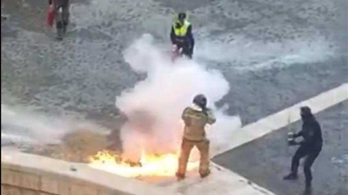 Llamas en el suelo en el momento en que el bombero prende la mecha ante la Catedral de Murcia.