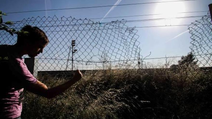 La valla metálica que acota las vías del tren está rota.