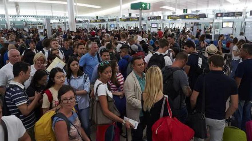 Centenars de viatgers s&#039;amunteguen als controls de seguretat de l&#039;aeroport d&#039;El Prat, ahir.