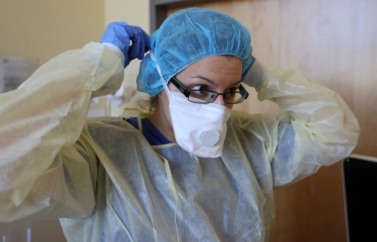 A member of the medical staff adjusts her face mask before treating a patient suffering from the coronavirus disease (COVID-19) in an intensive care unit at Havelhoehe community hospital in Berlin, Germany, April 6, 2020. REUTERS/Fabrizio Bensch