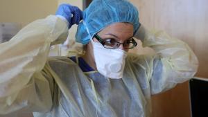 A member of the medical staff adjusts her face mask before treating a patient suffering from the coronavirus disease (COVID-19) in an intensive care unit at Havelhoehe community hospital in Berlin, Germany, April 6, 2020. REUTERS/Fabrizio Bensch