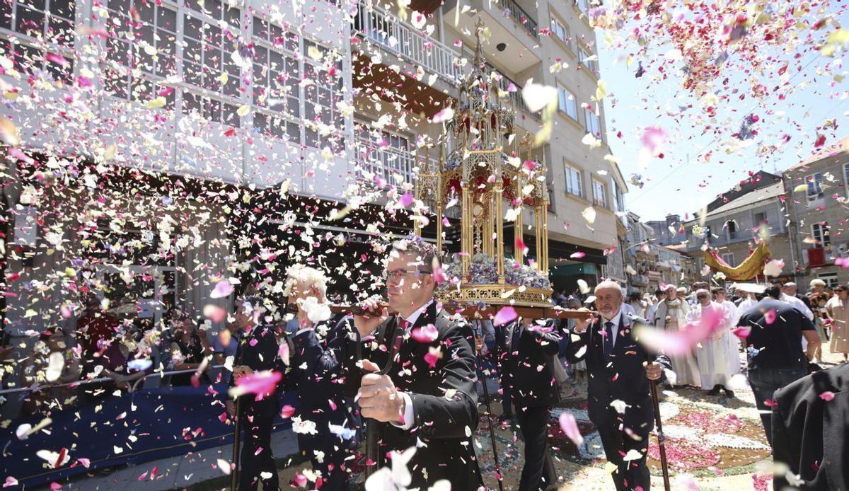 Lluvia de pétalos durante el paso de la procesión de Corpus sobre las alfombras florales en Ponteareas.