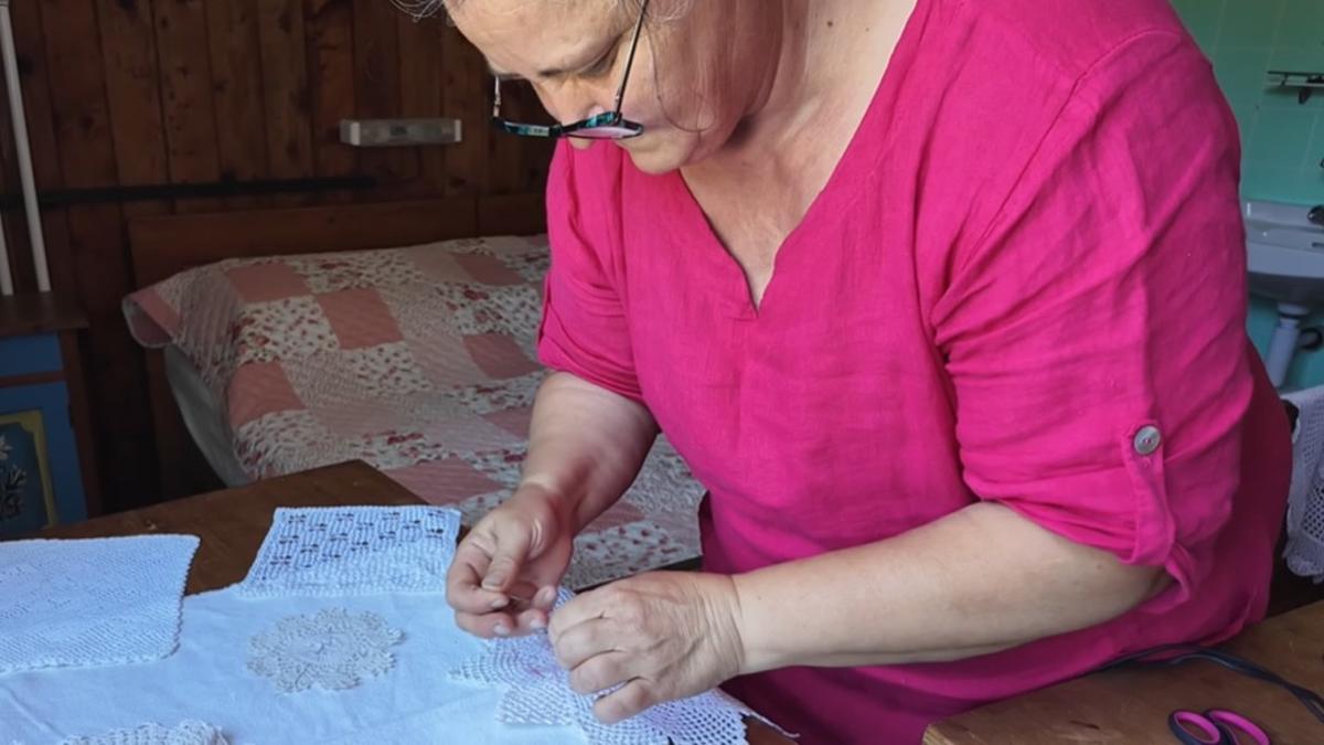 Magdalena cosiendo en su casa aislada en las montañas.