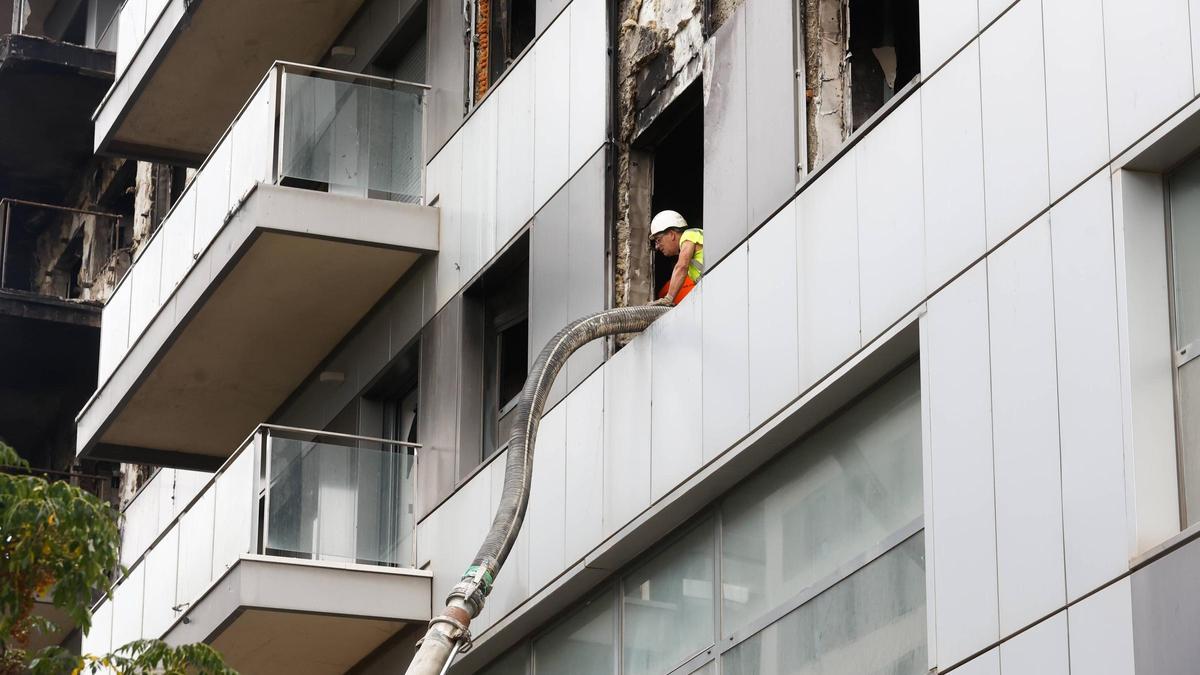 Un operari extrau els residus sòlids d’una de les vivendes