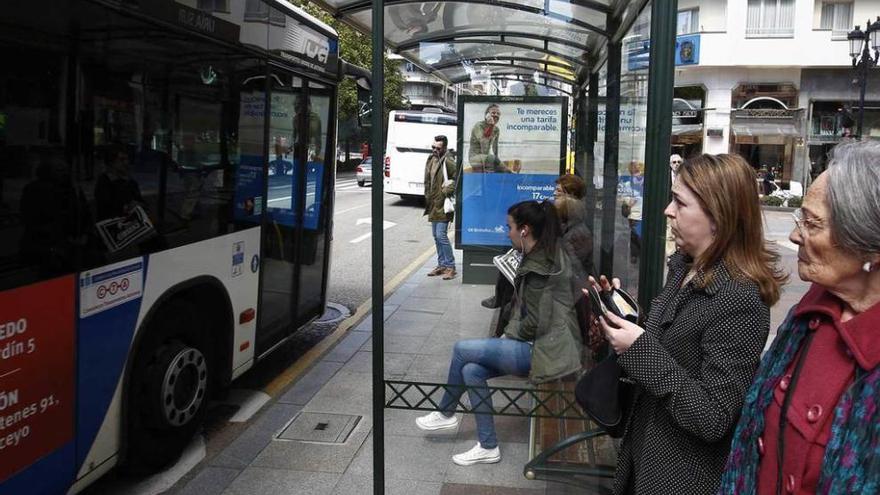 Usuarios del autobús urbano en la parada de Uría Sur.