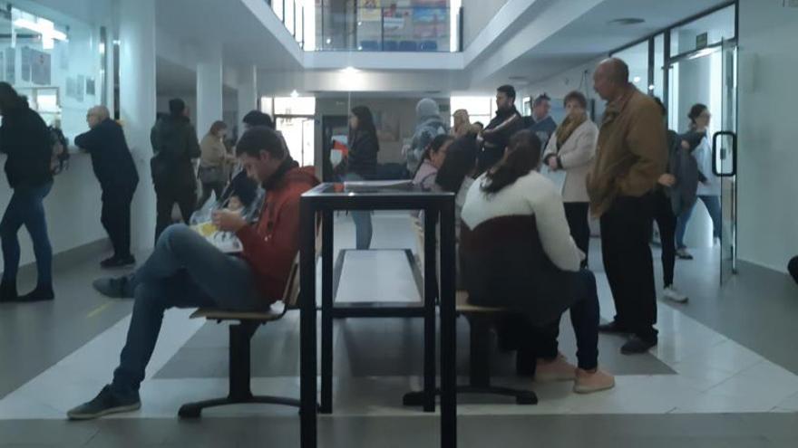 Varias personas esperan a ser atendidas en el mostrador del centro de salud de Mutxamel.