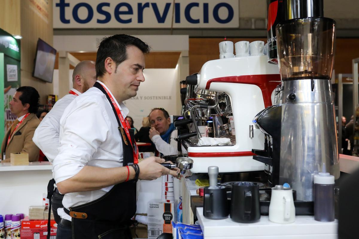 Un camarero preparando un café en un bar.