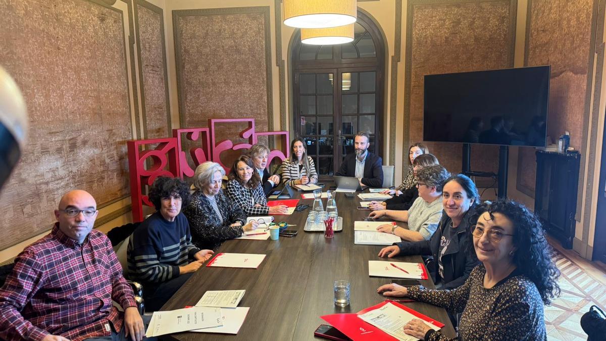 Ángela Pumariega, al fondo junto a Daniel Martínez Junquera, director de Visita Gijón, en la Mesa de Turismo de Gijón