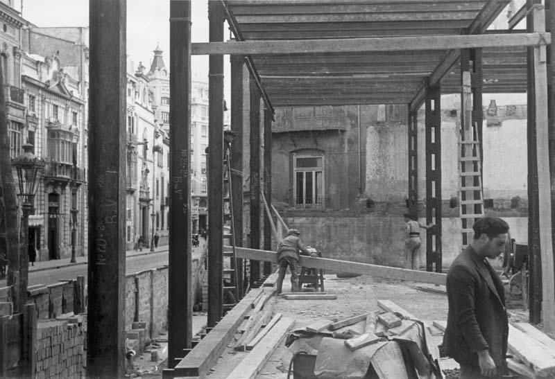 Los operarios del acero   Las 45 fotografías  realizadas entre 1935 y 1936, permiten conocer los métodos de construcción de la época, los materiales utilizados (cemento y acero, principalmente), los medios de transporte (carretas tiradas por burros) o las condiciones laborales de los trabajadores, que no disponían de grandes medidas de seguridad (sin casco, por ejemplo) y vestían con ropa de calle. Las fotografías de esta página muestran los trabajos en el sótano del edificio.